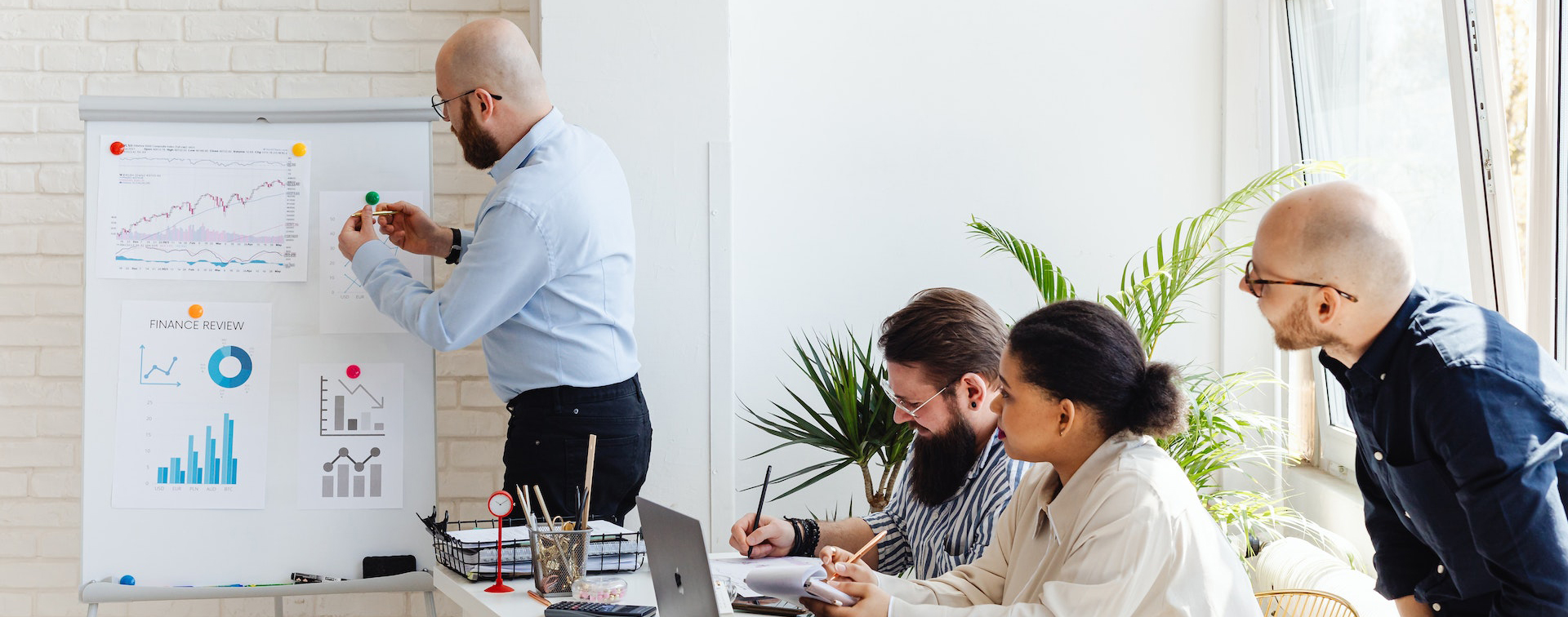 team leader making a demonstration on a whiteboard while other team members look on