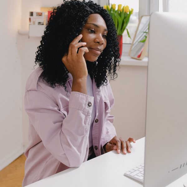 black woman on mobile phone in home office