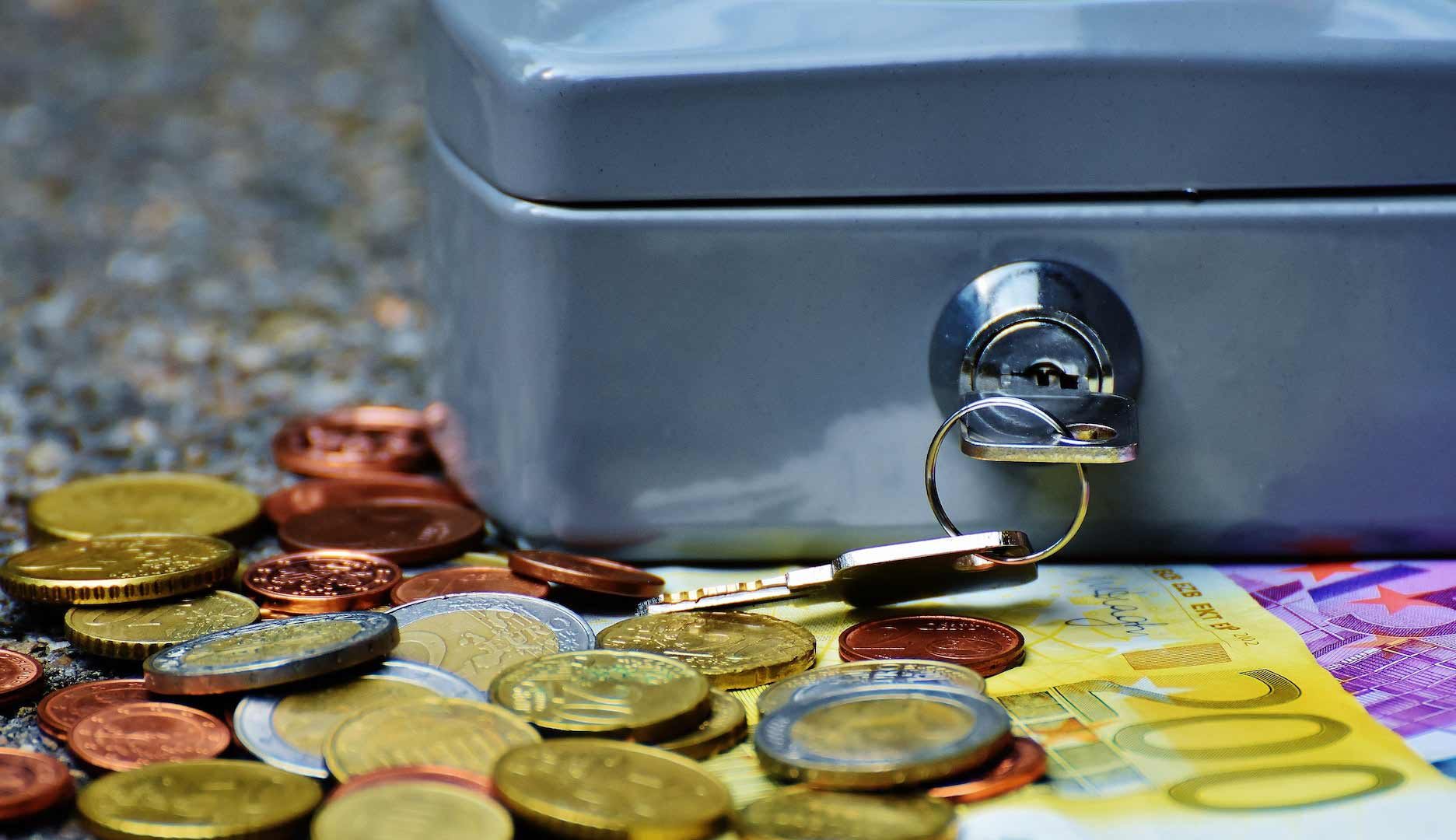 a petty cash box on a table with coins and notes